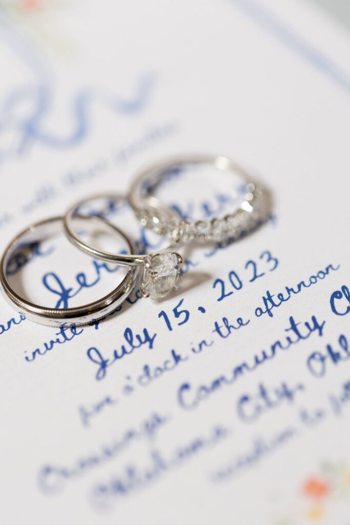 Rings on a blue cursive wedding invitation