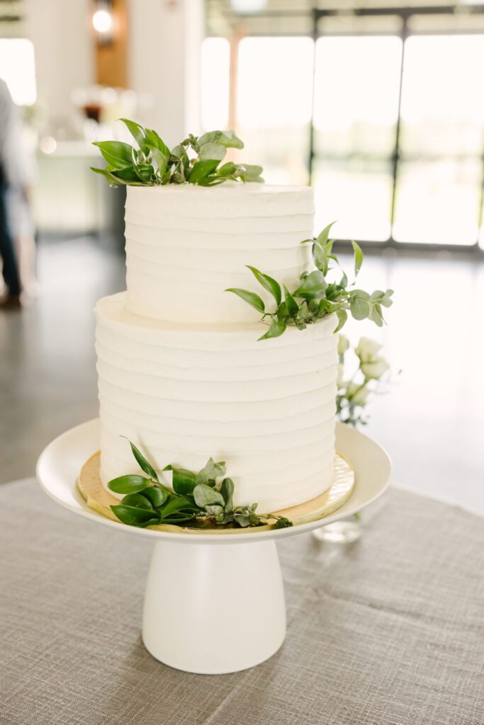 white wedding cake with greenery